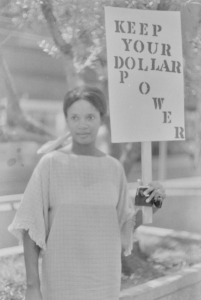 woman with "keep your dollar power" sign